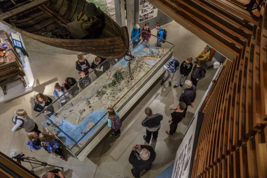 Ylhäältä päin otetussa valokuvassa on eri-ikäisiä ihmisiä katsomassa näyttelyvitriiniä. Suuri osa katsojista on lapsia.