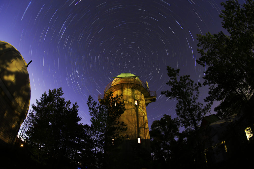 Valokuvassa näkyy Turlan observatorion tähtitorni ja sen takana tähtitaivas.